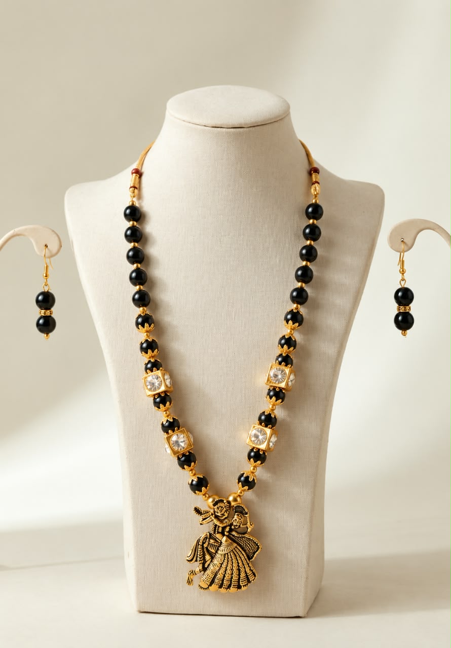 Antique Gold Plated Radha Krishna Pendant Long Necklace Set with Black Beads, Kundan Work & Matching Drop Earrings.